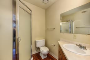 Bathroom with Toilet, Shower, Hardwood Inspired Floors and Sink 