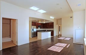 Midtown Sacramento, CA Apartments for Rent - Spacious Living Room with Wood Flooring, a Large Window, and Seamless Access to Kitchen