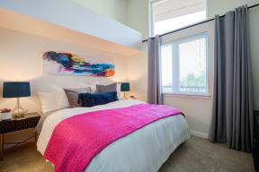 Bedroom with Wide Bed, Pink Blanket, White Comforter, Carpet, Open Window and Curtains