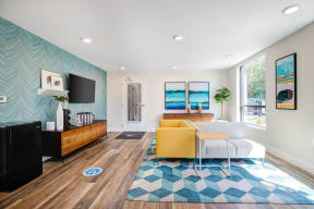 Living Room with Wood Inspired Floor, Flat Screen Television Mounted to Wall, Blue Cube Designed Rug, Mini Fridge