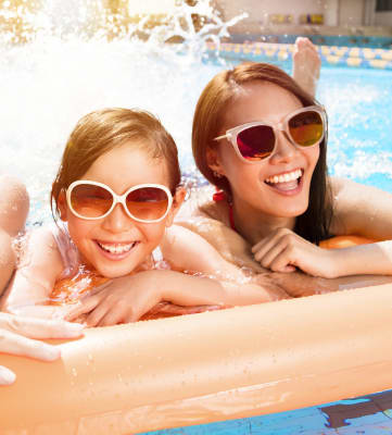 Family playing in the pool and sun
