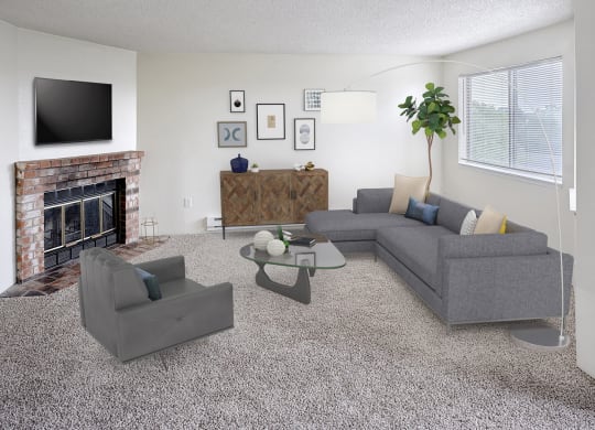 Living room with couch and chair with coffee table in the middle.  Decorated with a plant, floorlamp, and wall art, with a tv above the fireplace.