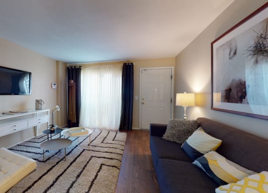 Victorville, CA Apartments - Aspire of the High Desert - Large Living Room with Wood-Style Flooring, Stylish Decor, and a Large Window