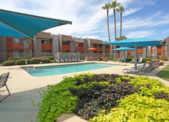 Apartments North Phoenix for Rent - Sierra Pines - Pool Area with Lounge Chairs, Tables, and Umbrellas