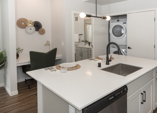 a kitchen with a sink and a washer and dryer in a 555 waverly