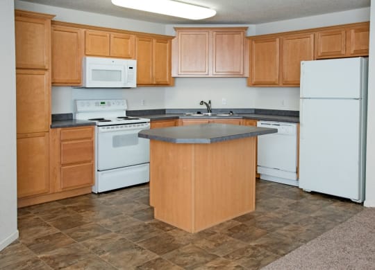 kitchen with oak cabinetry, appliances, kitchen island