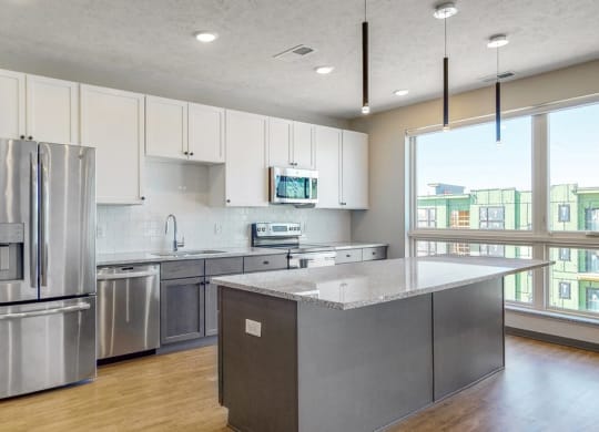 Large windows filter abundant natural light into the spacious kitchen in the Melody floor plan at Haven at Uptown in Lincoln, NE