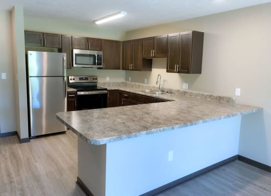 Renovated kitchen with lots of granite counter top space and stainless steel