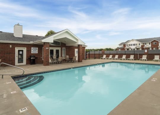 Resort style swimming pool with sun tanning loungers at Ridge Pointe Villas in South Lincoln Nebraska