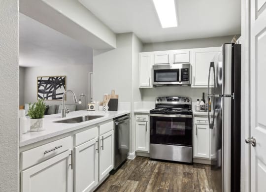 Model kitchen with white cabinets and stainless steel appliances