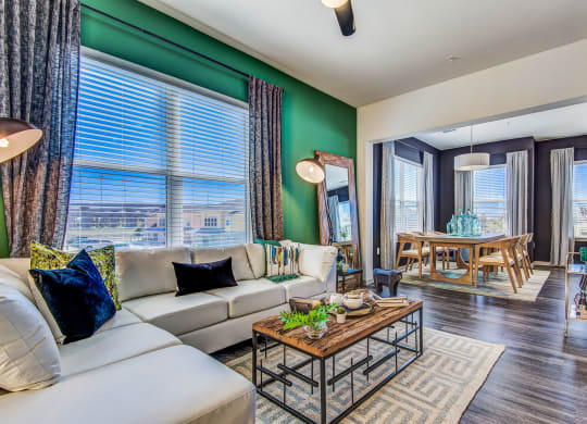 Apartments for Rent Lewisville TX - Hebron 121 Station - Living Room Equipped With Modern Furniture and Dining Room Table With Wooden Chairs