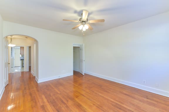 vacant living area with hardwood flooring, ceiling fan and view of kitchen at 4020 calvert street apartments in washington dc