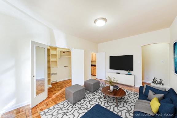 living area with hardwood flooring, social seating, coffee table and tv at baystate apartments in washington dc
