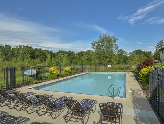 Sparkling Fenced-In Pool and Sundeck with Lounge Chairs