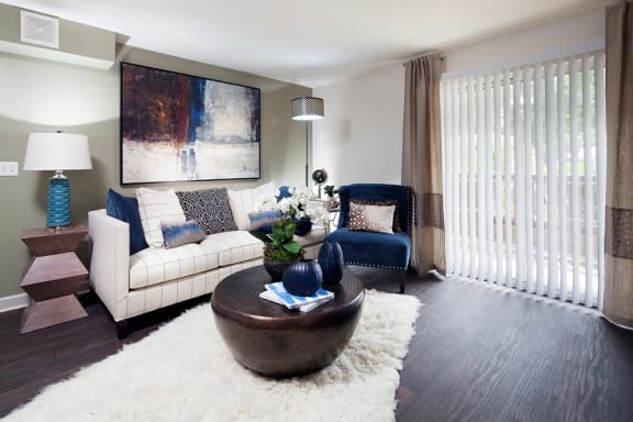 Ardenne Apartments model apartments with a white couch, blue chair and hardwood-style floor