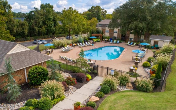 Large swimming pool surrounded by gorgeously maintained landscaping