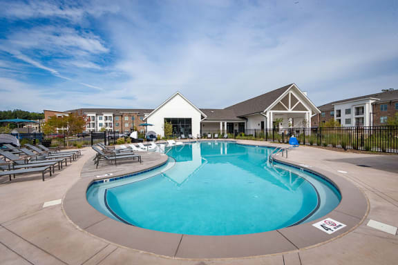 Swimming pool with large sundeck has lounge chairs at Pointe at Research Park
