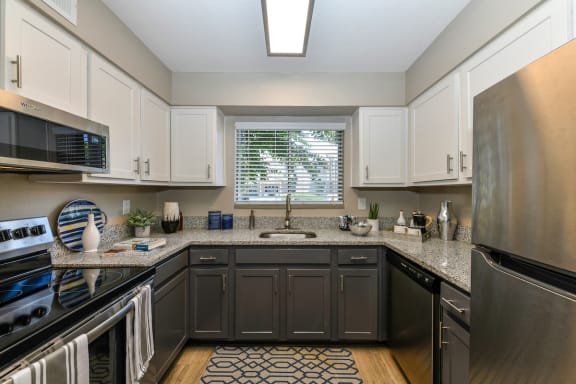 kitchen with stainless steel appliances, granite countertops, and hardwood-style flooring