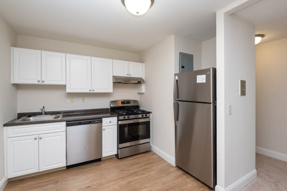 Quincy commons kitchen with white finishes, high quality flooring, and stainless steel appliances