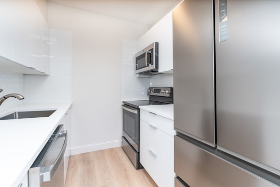 Babcock Tower two bedroom kitchen with stainless appliances, bright white finishes, microwave, bifold refridgerator