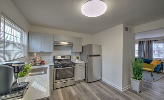 kitchen at Crestwood at Libbie apartments in Richmond, VA with stainless steel appliances, light cabinets, hardwood flooring and stone countertops