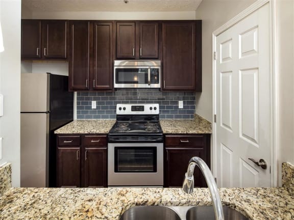 Renovated Kitchens with Granite Countertops and Breakfast Bar with Tiled Backsplash at Park Summit Apartments, Decatur, GA 30033?