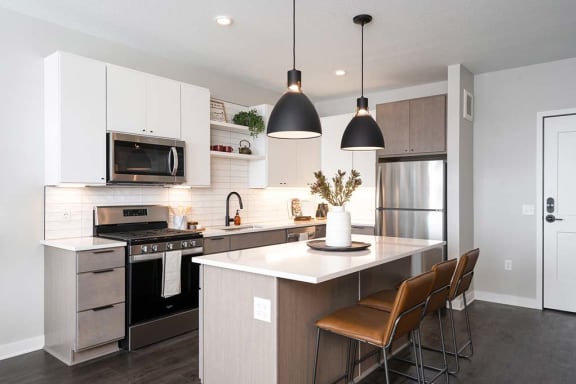 a kitchen with a center island next to a stove top oven