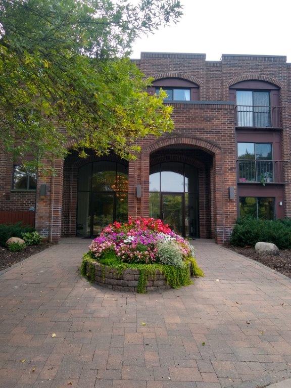 a large brick building with a flower garden in front of it