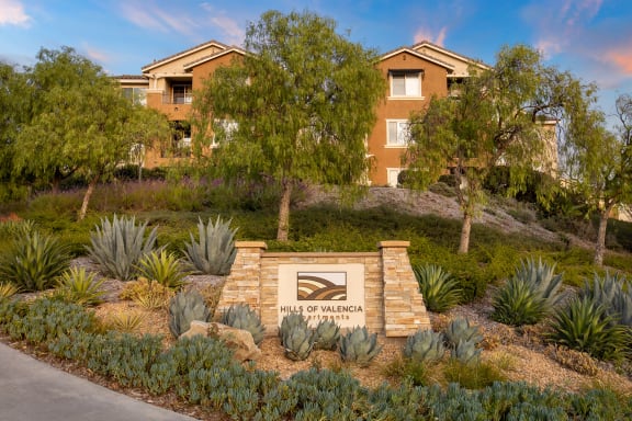 Hills of Valencia Apartments entrance signage and greenery
