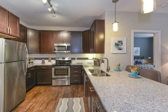 Open concept kitchen with granite countertops at Axis Berewick Apartments in Charlotte, NC