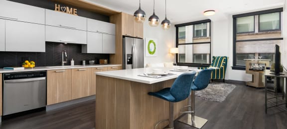 Millennium on LaSalle-Kitchen-White Countertops, Dark Wood-Style Floors, Modern Brown Cabinets, Stainless Steel Appliances, and Blue Stool Chairs
