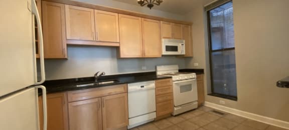 Kitchen featuring granite countertops, dishwasher and gas range