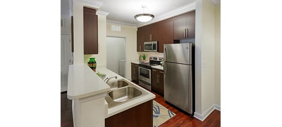 Kitchen with stainless steel appliances; door to laundry area