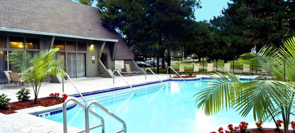 Large swimming pool with poolside lounge chairs, beautiful landscaping, park-like setting, scenic views, and luxury resident clubhouse at Alpine Village Apartments in La Vista, Nebraska