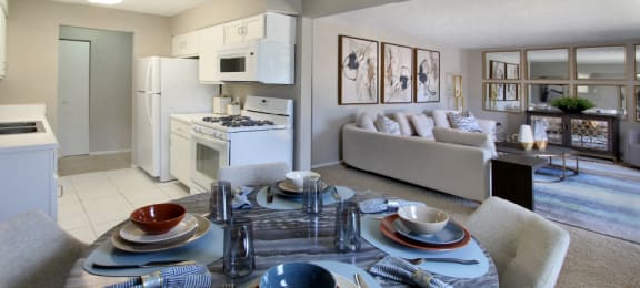 Spacious apartments with lots of natural light, spacious living room, spacious dining room, huge apartment, spacious floor plan, bright white kitchen, white kitchen cabinets, and gray wall color at Inwood Apartments in La Vista, Nebraska