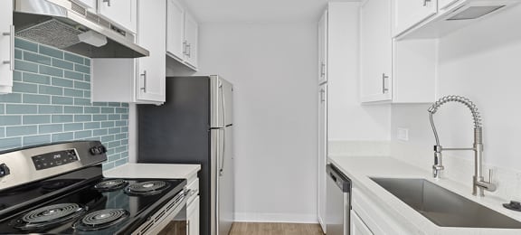 Riviera De Ville updated kitchen with white cabinetry and full size stainless steel appliances