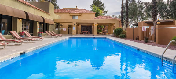 ridgepointe pool view with nice lounging area and trees surrounding