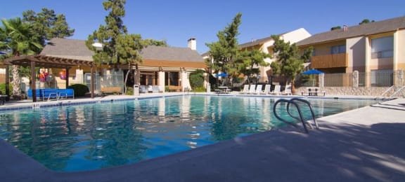 Pool, lounge chairs, apt building  El Paso, Texas Apartments For Rent l Ridgemar Apartments