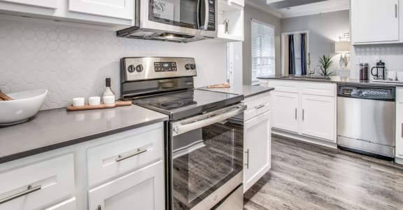 North Dallas TX Apartments- Spacious Modern Kitchen With Gray Granite Countertops, White Cabinets, and Stainless Steel Appliances
