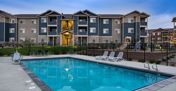 Pool view with lounge chairs and apts buildings Apts in Andrews Heights, WA 99001 | Copper Landing