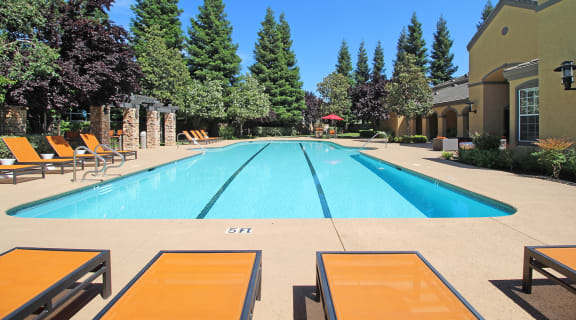 Pool with Lounge Chairs l Oak Brook Apartments in Rancho Cordova CA 