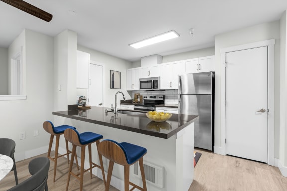 a kitchen with a large center island with a breakfast bar and three stools