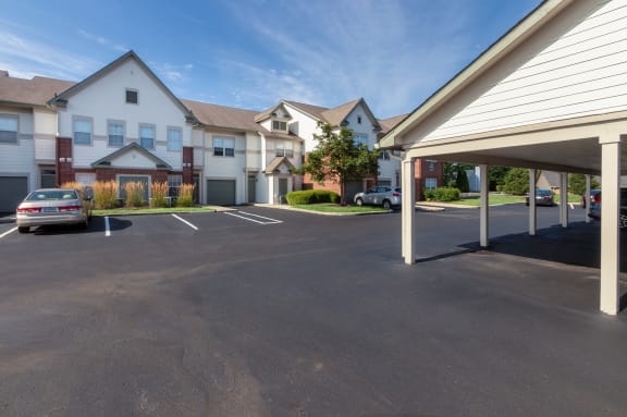 This is a photo of apartment exteriors showing private entrances, attached garages and covered parking at The Sanctuary at Fishers in Fishers, IN.