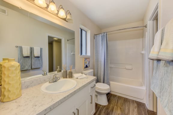 Bathroom with Quartz Counters, Hardwood Inspired Floor, Toilet and Vanity