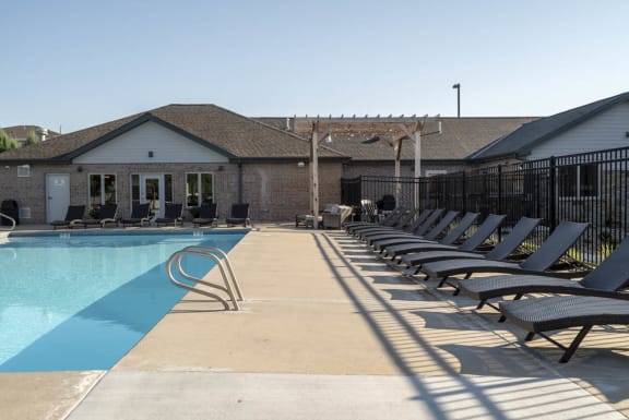 Resort style swimming pool with sun tanning loungers at Highland View Apartments in North West Lincoln Nebraska