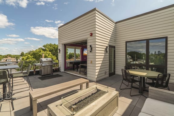 Rooftop patio with grill station and outdoor firepit at The Central apartments near downtown Minneapolis MN 55408