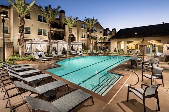 Pool with lounge chairs neat building l Solimar Apartments for rent in  Wilmington CA