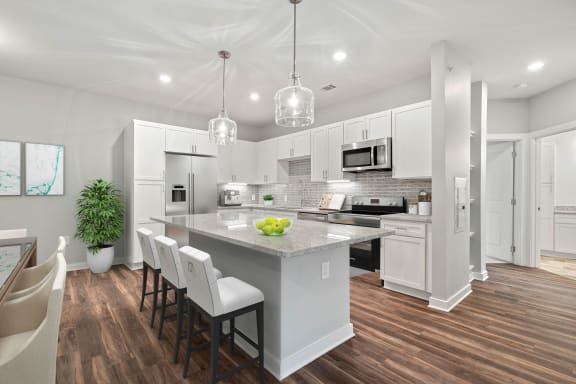 Beautiful gourmet kitchen with white cabinets, granite countertops, stainless steel appliances and designer lighting