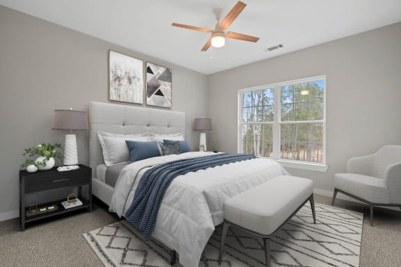Spacious bedroom with a lighted ceiling fan and large window at 8 West in Greensboro, NC