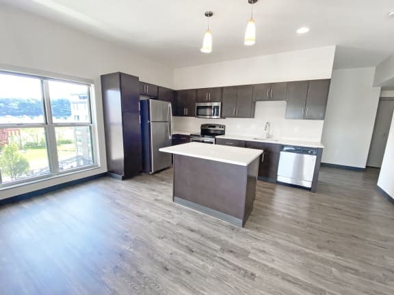 an open floor plan with an island and stainless steel appliances